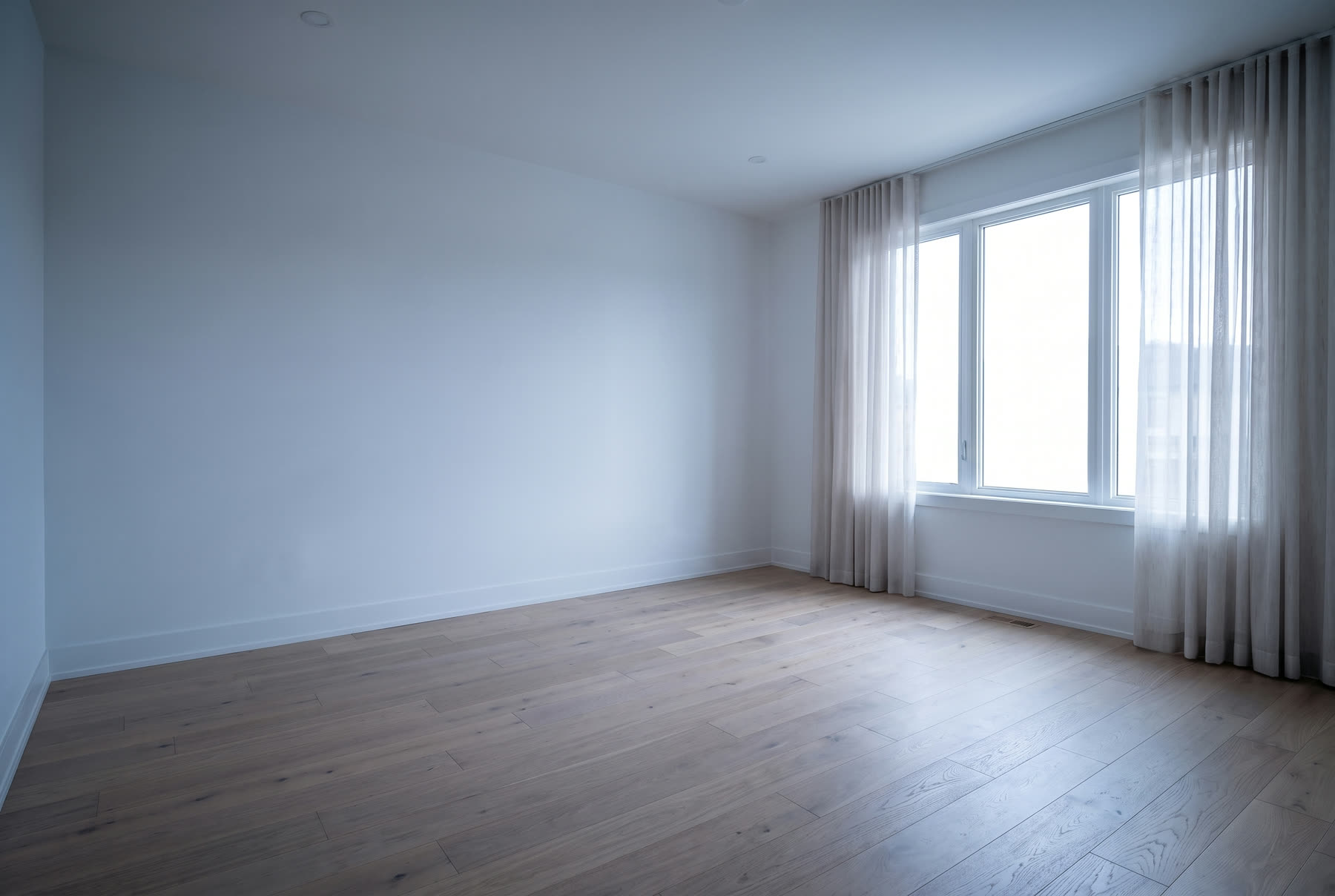 The same bedroom completely empty, shot dim and slightly tilted on a phone.